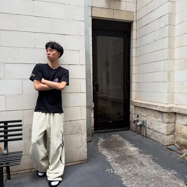레이 — 벽 앞의 멀티컬러 크로스 티셔츠